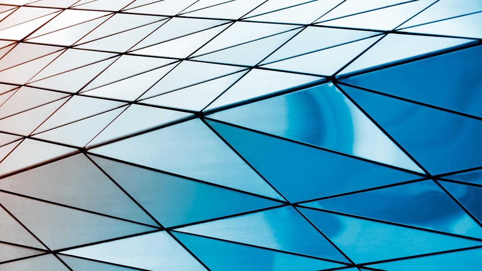 Metal building exterior of patterned triangles with colour fade.