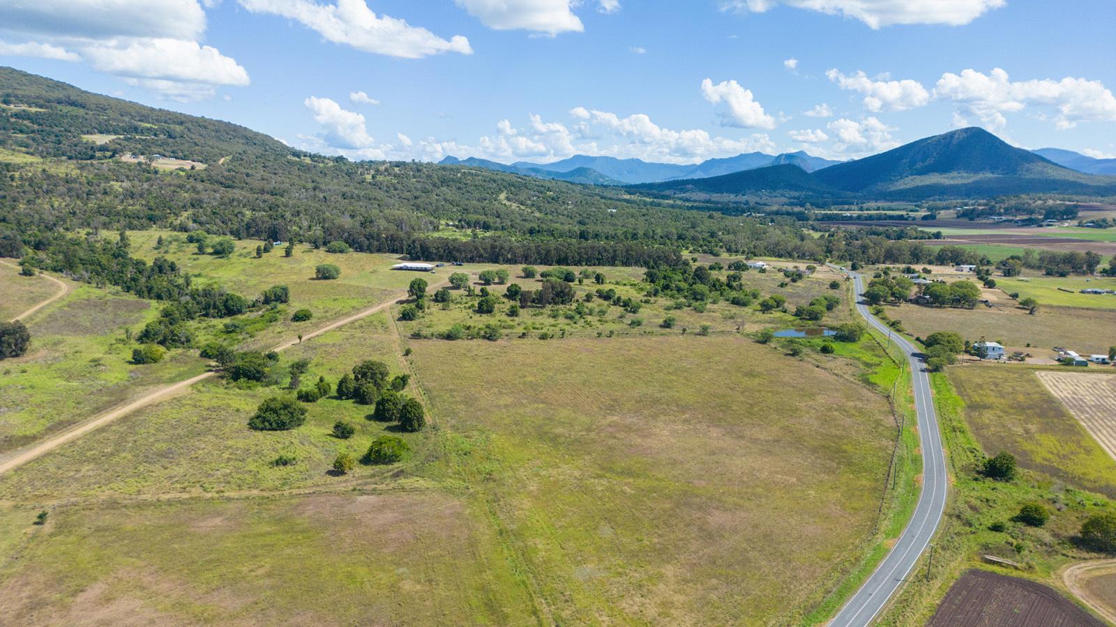 Rural farmland with country road near Boonah, Queensland, with a view of the Great Dividing Range in the background.