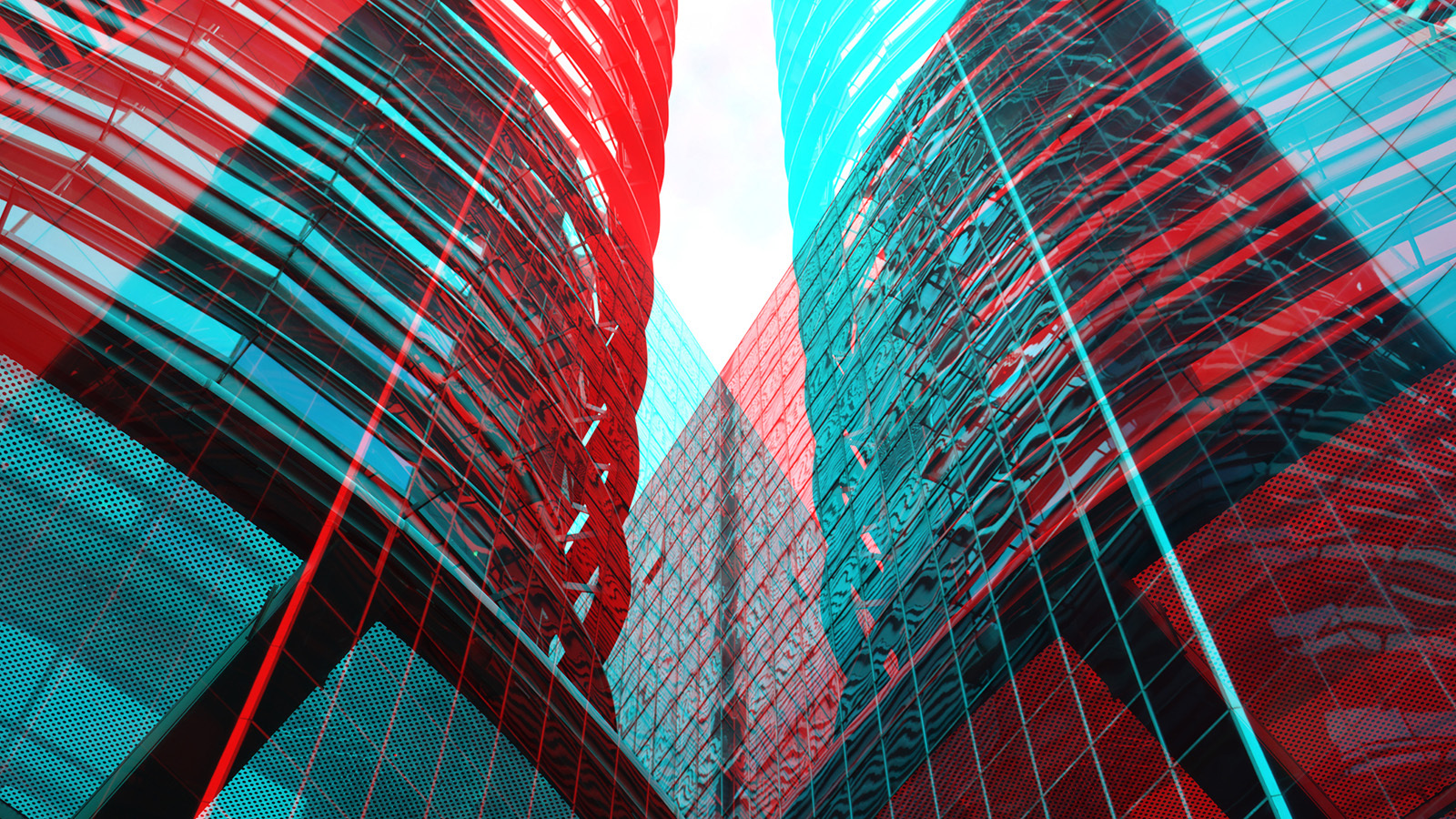 A double exposure photograph of two office buildings in red and aqua colourings. Intended to depict the 'double trouble' concept.